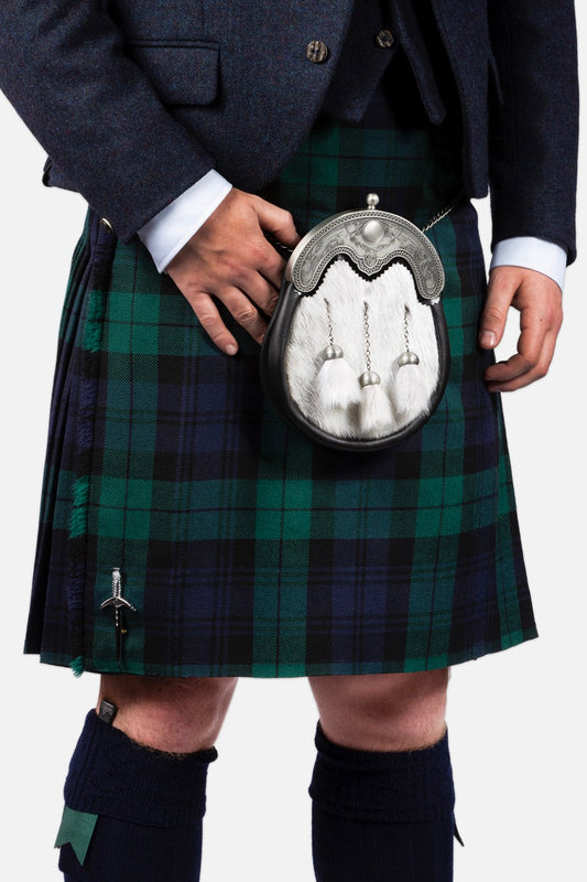 A man is wearing a Black Watch Tartan Kilt with White Sporran and Blue Tweed Jacket